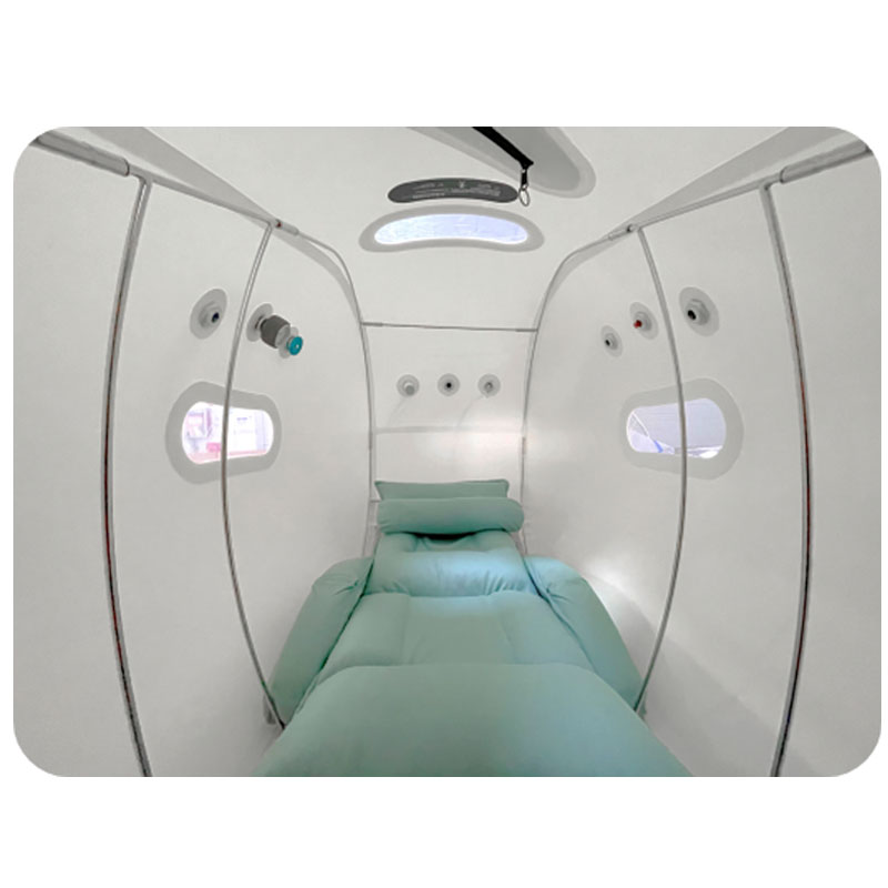 Used hyperbaric chamber Atlanta interior — inside view of the OXYREVO Forward90 Pro showing the sage green mattress with pillows, four large viewing windows, ceiling LED reading light, pressure gauges, oxygen mask hookup and pressure-relief valves. Spacious one-adult-plus-child capacity. For sale in Buckhead, Atlanta GA.